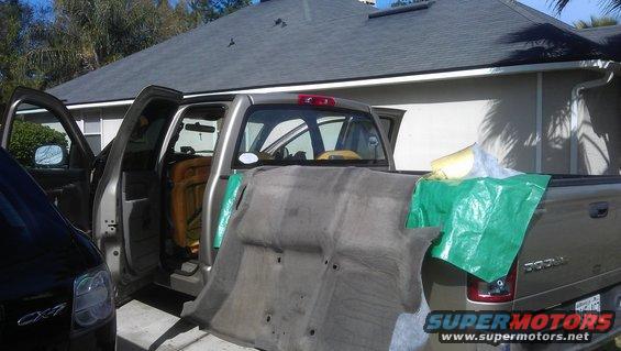 Silver pickup truck side view, interior carpet removed, another vehicle partially visible