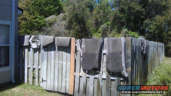 Car seat covers and parts hanging on a wooden fence