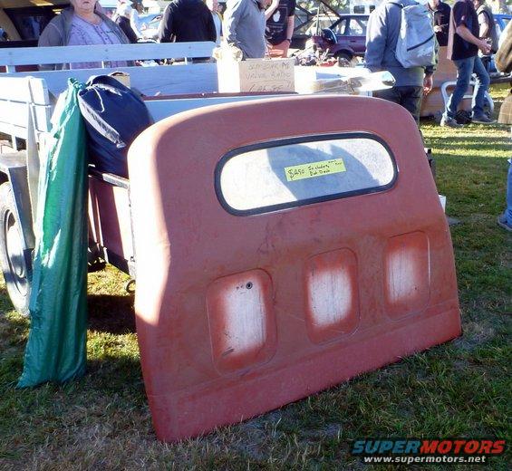 Red tailgate with window and three indentations, yellow price tag on window