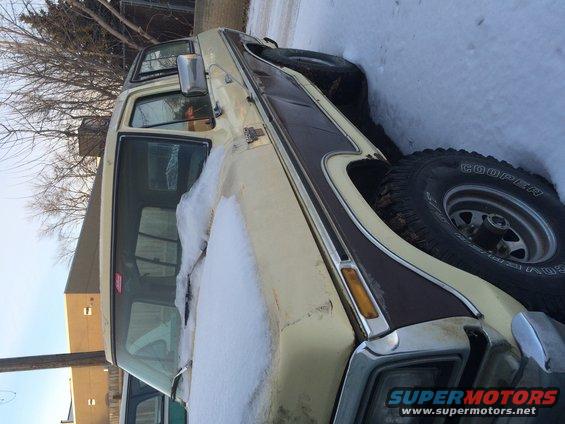 1978 Ford Bronco in tan and brown, covered in snow, parked outdoors