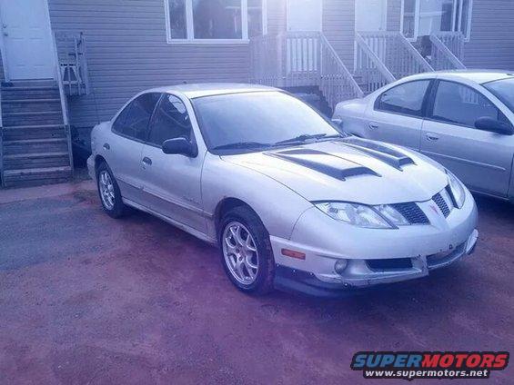 Silver Pontiac Sunfire with hood scoops parked next to another car