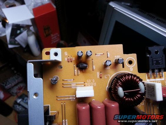 Close-up of a circuit board with various electronic components, including capacitors, resistors, and a transistor