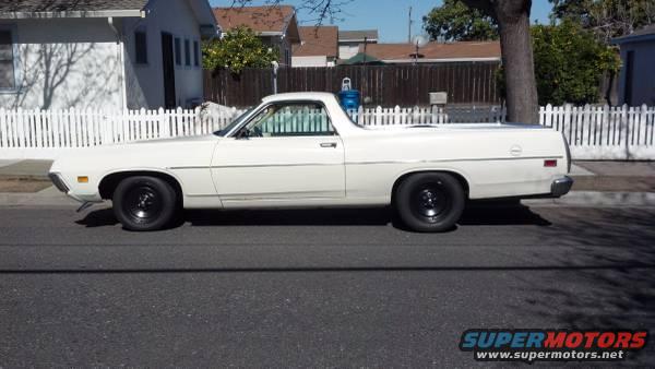 White 1970 Ford Ranchero with black wheels parked on a residential street