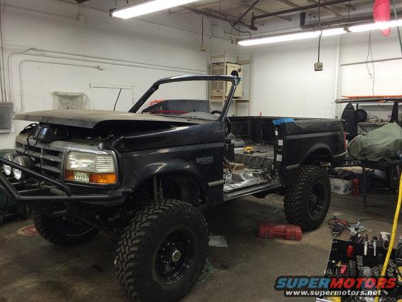 1992 Ford Bronco with hood open, doors removed, in a garage