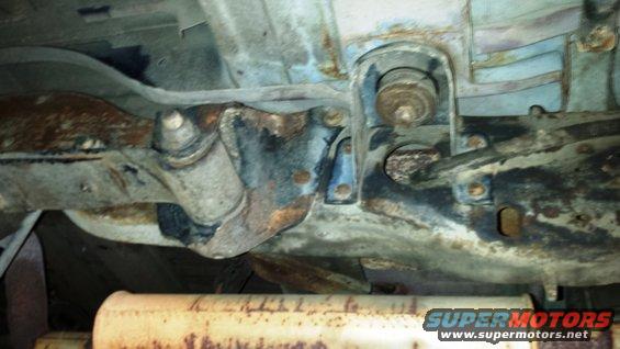Undercarriage of a rusty vehicle with exhaust pipe visible