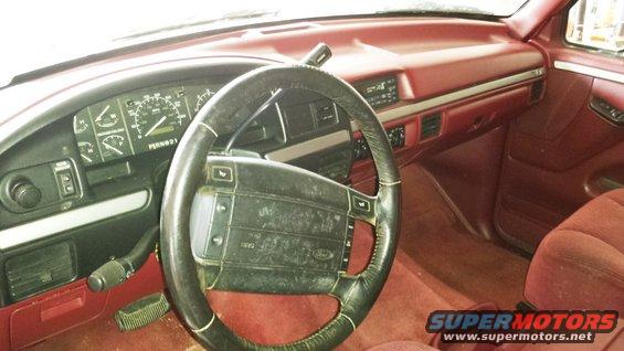 Interior view of a 1994 Ford Bronco with red upholstery and a black steering wheel