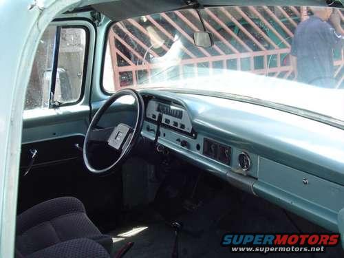 Interior of a light blue 1960s truck, showing dashboard and steering wheel