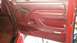 2001 Ford F-150 - Interior view of a red door panel with a silver trim strip above the window controls.