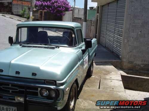 Light blue pickup truck parked on a concrete surface, front quarter view. License plate reads DA-8714