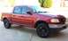 2001 Ford F-150 - This red 2001 Ford F-150 pickup truck is viewed from a three-quarter front angle.