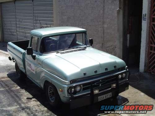Light blue 1967 Ford F-100 pickup truck with a black grille guard and "TAXI" text on the door