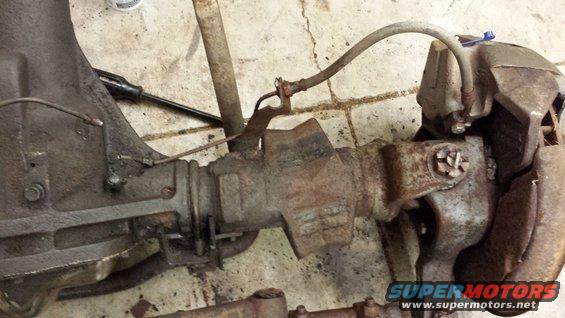 close-up of a rusty rear axle assembly with brake lines