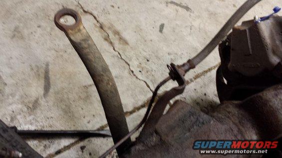 Rusted metal components on a concrete floor with a SuperMotors.net watermark