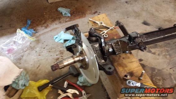 Vehicle front axle assembly with brake rotor and suspension components on wooden blocks