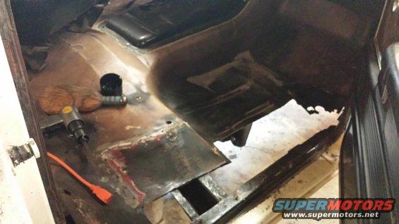 rusted floor pan with a pneumatic tool and orange cord