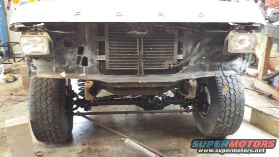 Front view of a disassembled Ford truck, showing the grille, headlights, and suspension
