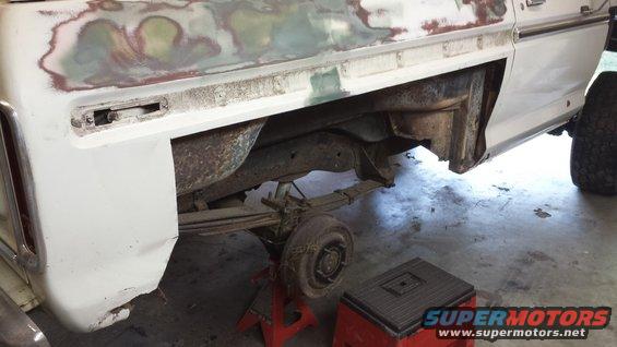 White 1978 Ford Bronco rear quarter panel undergoing repair, showing rust and bodywork