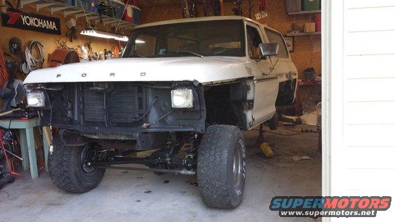 1978 Ford Bronco with front end removed, lifted in a garage
