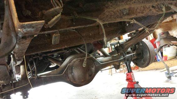 1978 Ford Bronco rear axle and leaf spring suspension on jack stands, showing rust and wear