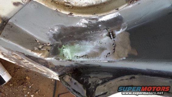 Close-up of rusted metal with welding repairs on a vehicle part