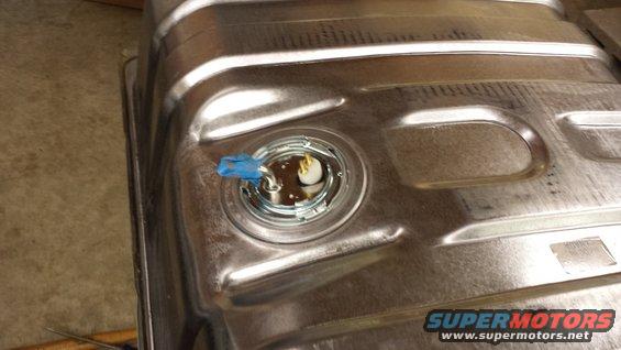Close-up of a fuel tank sender unit with blue tape on the connector