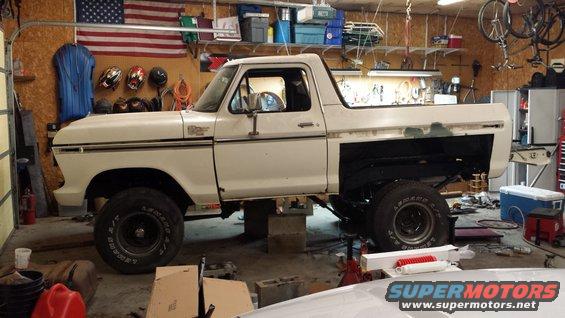 White 1978 Ford Bronco in a garage, lifted on blocks