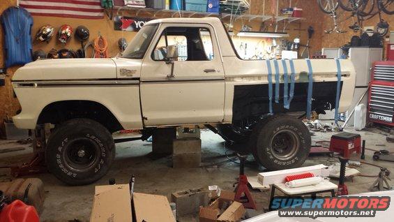 White 1978 Ford Bronco on jack stands in a garage, side view