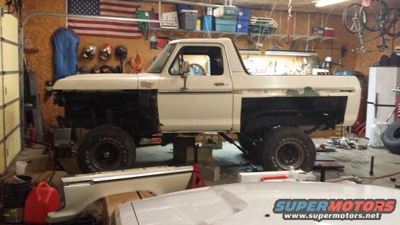 White 1978 Ford Bronco lifted in a garage with front end removed