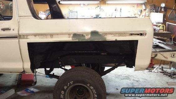 Side view of a white 1978 Ford Bronco undergoing body repair in a garage