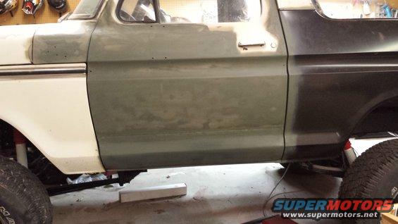 1978 Ford Bronco side panels undergoing repair, showing primer and dark paint