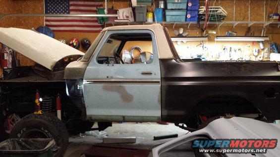 1978 Ford Bronco with hood open and body panels removed, in a garage