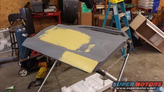 Car door with yellow primer on stand