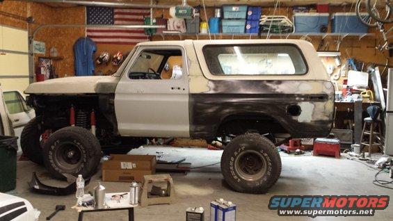 1978 Ford Bronco in garage with primer and body filler on fenders and doors