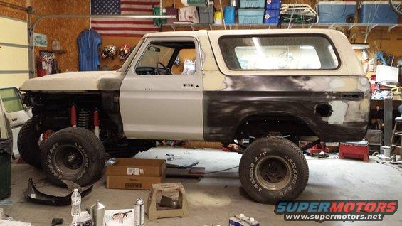 Ford Bronco undergoing bodywork in a garage, front fender removed, showing suspension