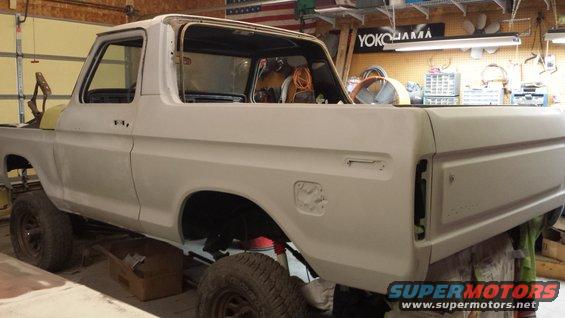 1978 Ford Bronco body in primer, undergoing restoration in a garage