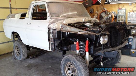 1978 Ford Bronco in garage, front end removed, red shocks visible
