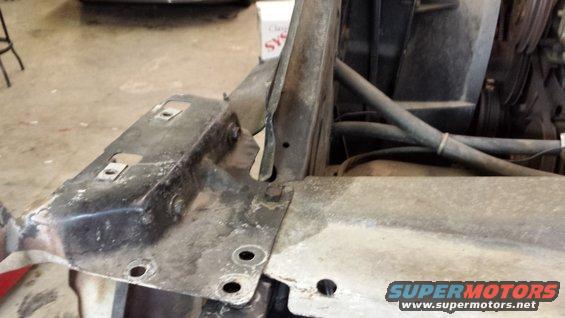 Close-up of metal brackets and hoses in a vehicle's engine bay
