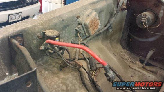 Engine bay wiring with red cable and electrical components