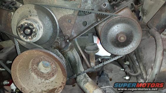 Engine bay with belts and pulleys, oil filter visible