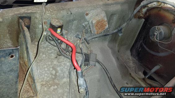 Engine bay wiring with red battery cable and fuse box