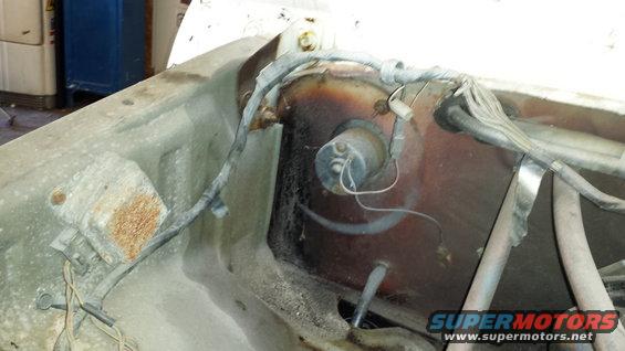 Close-up of engine bay wiring and components. Shows rust and dirt
