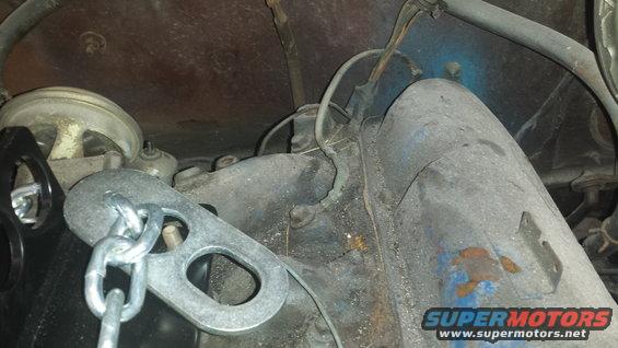 Engine components with a chain hoist attached to a metal bracket
