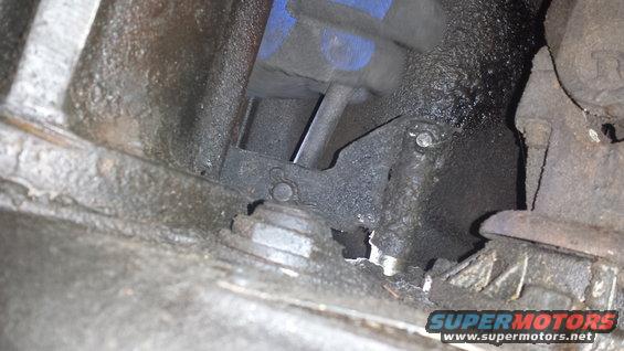 Engine part with blue and black components, greasy metal
