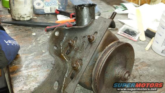 Power steering pump on a workbench with tools and parts nearby