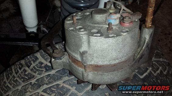 Close-up of a vehicle alternator sitting on a tire