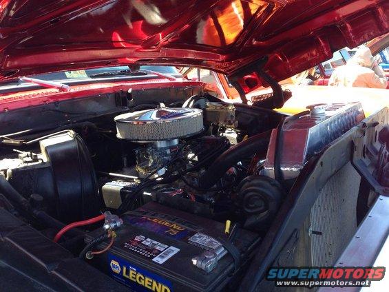 Red vehicle engine bay with chrome air cleaner and NAPA Legend battery