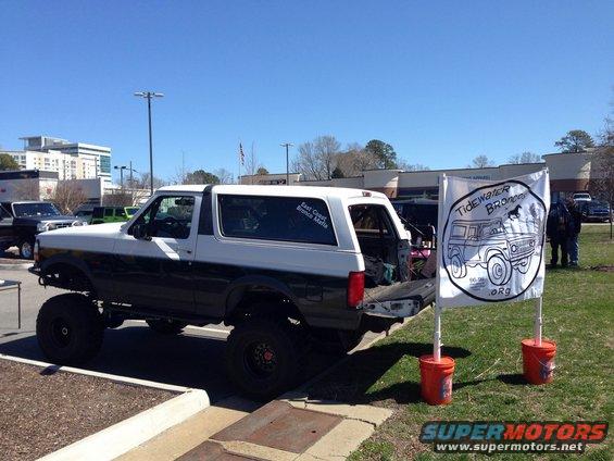 White and dark green lifted Ford Bronco with off-road tires, parked outdoors