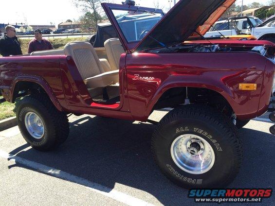 Red convertible SUV with tan interior, hood open, parked on asphalt