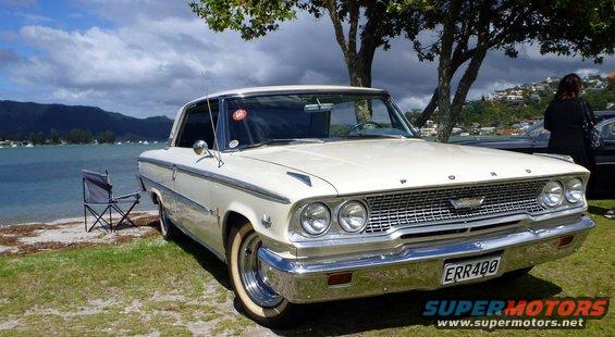 White 1963 Ford Galaxie 500 parked by a lake with a folding chair