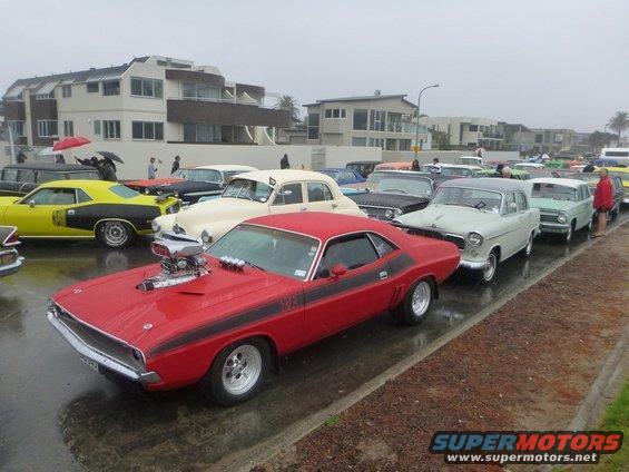 Red muscle car with supercharger and black racing stripes